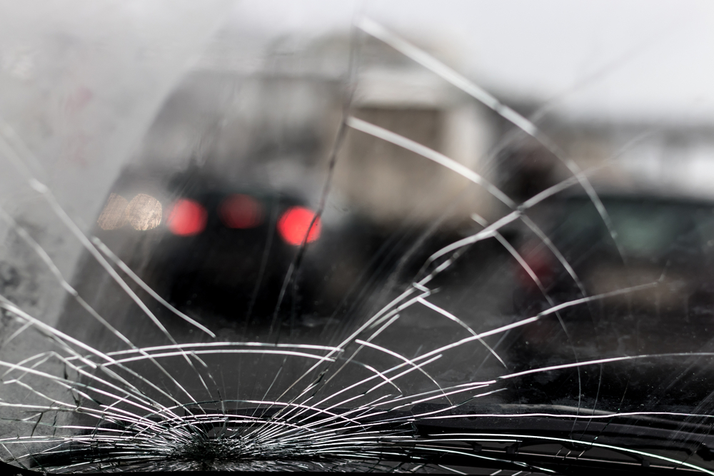 view of broken windshield as driver navigates busy roads
